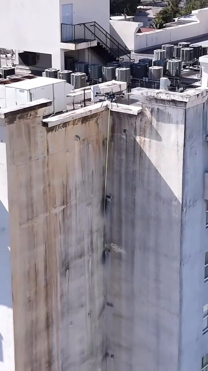 Drone cleaning a rooftop of a high-rise building
