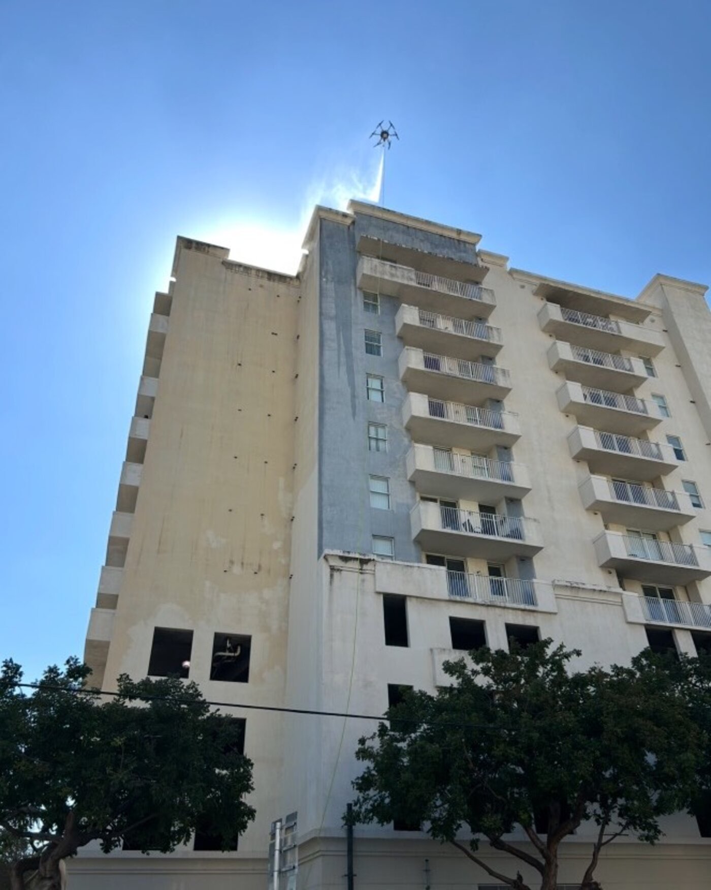 Drone applying cleaning solution to a facade